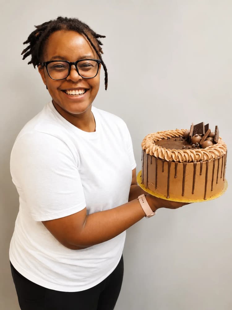 Alexandria Johnson, founder of Whiskly, holding a chocolate drip cake